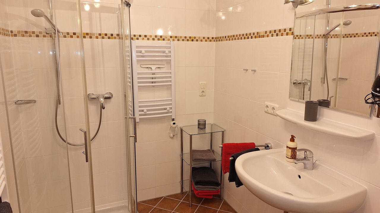 Badezimmer mit Dusche und Waschmaschine Badezimmer mit Dusche und Waschmaschine